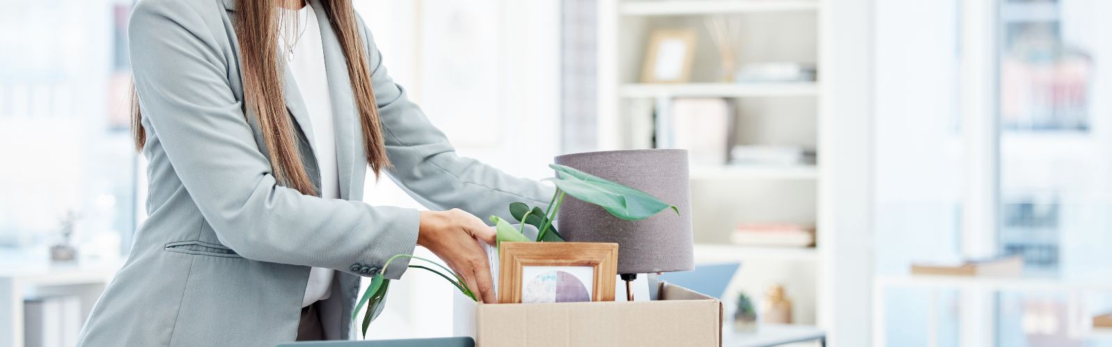 Funcionária demitida embalando itens pessoais no local de trabalho.