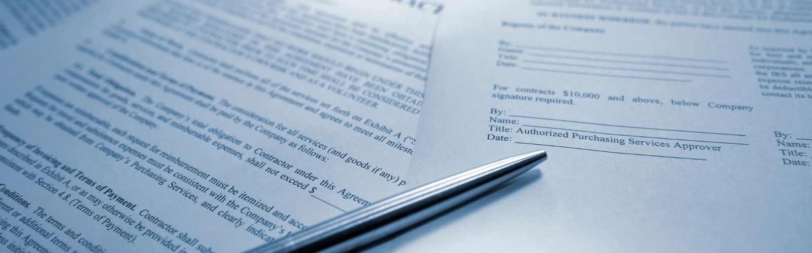 Documento formal impresso com cláusulas contratuais e caneta metálica ao lado, simbolizando contrato social cláusulas importantes.