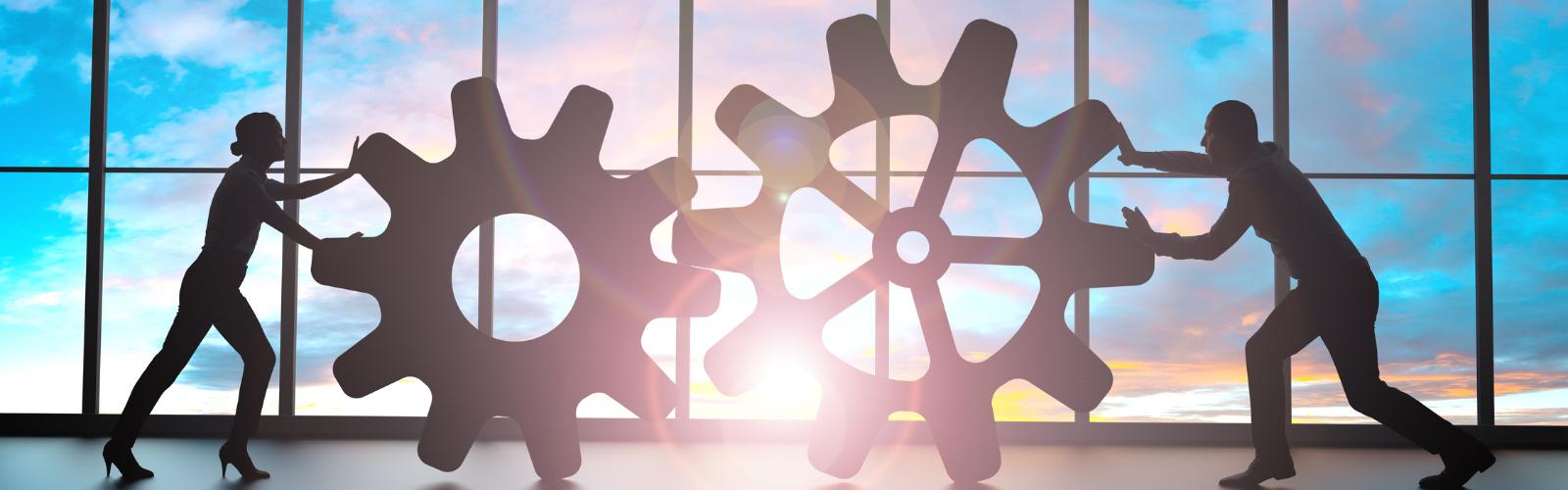 Duas pessoas empurrando engrenagens separadas, simbolizando separação e divisão de esforços em uma empresa. Separação e empresa: como proteger os bens do negócio em caso de divórcio.