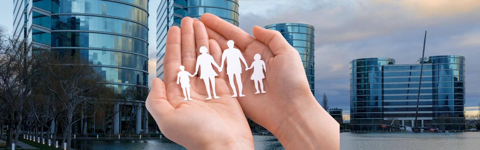 Mãos segurando silhuetas de uma família sobre fundo de edifícios comerciais modernos. Holding familiar e empresarial: quando vale a pena criar uma?